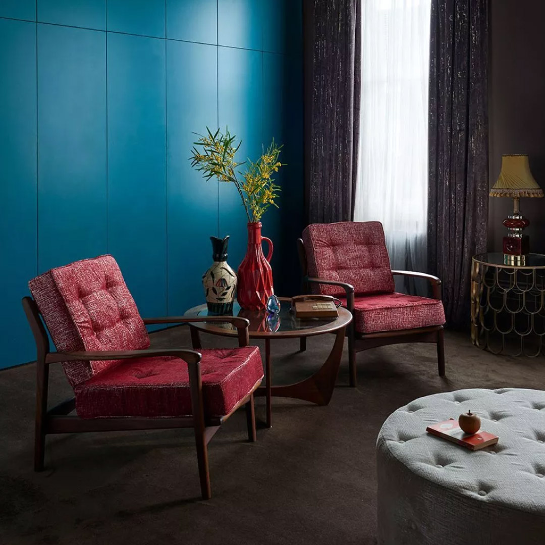 red upholstered chairs in a blue room